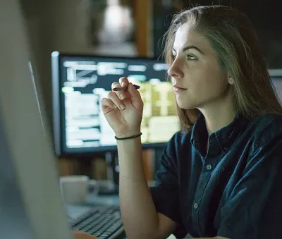 woman monitors dark office